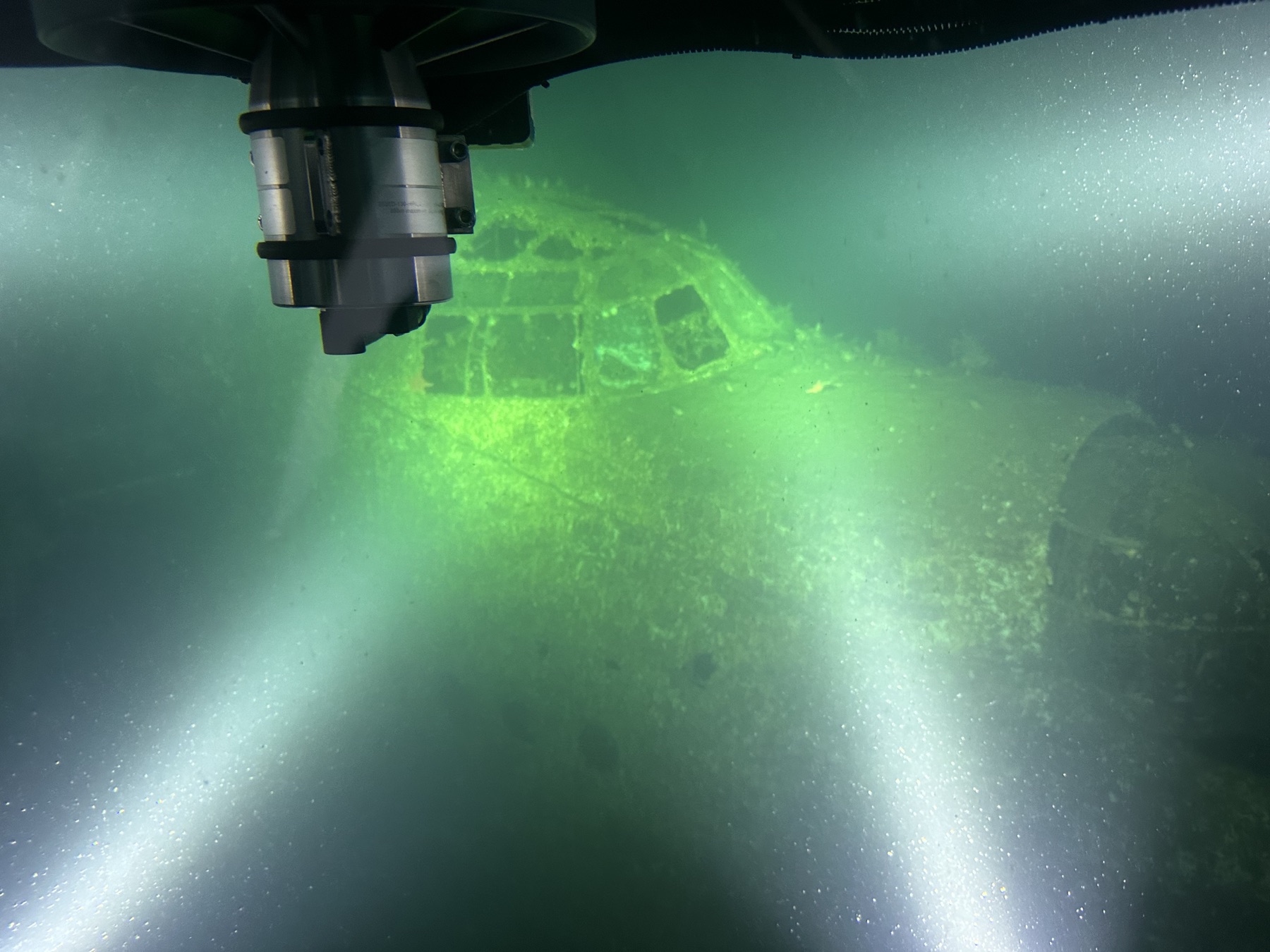 An underwater wreck illuminated by lights from an Arctic submarine